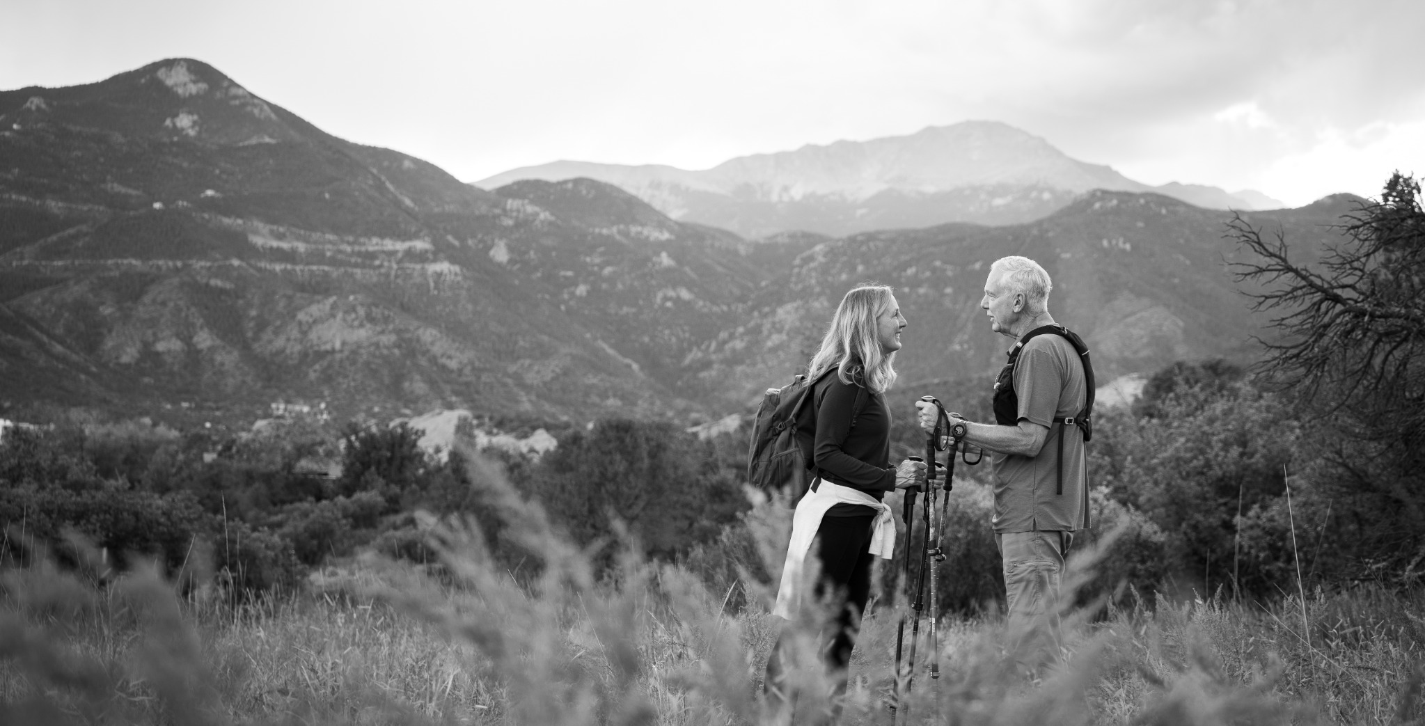 Couple sharing a moment on a mountain trail beneath Pikes Peak